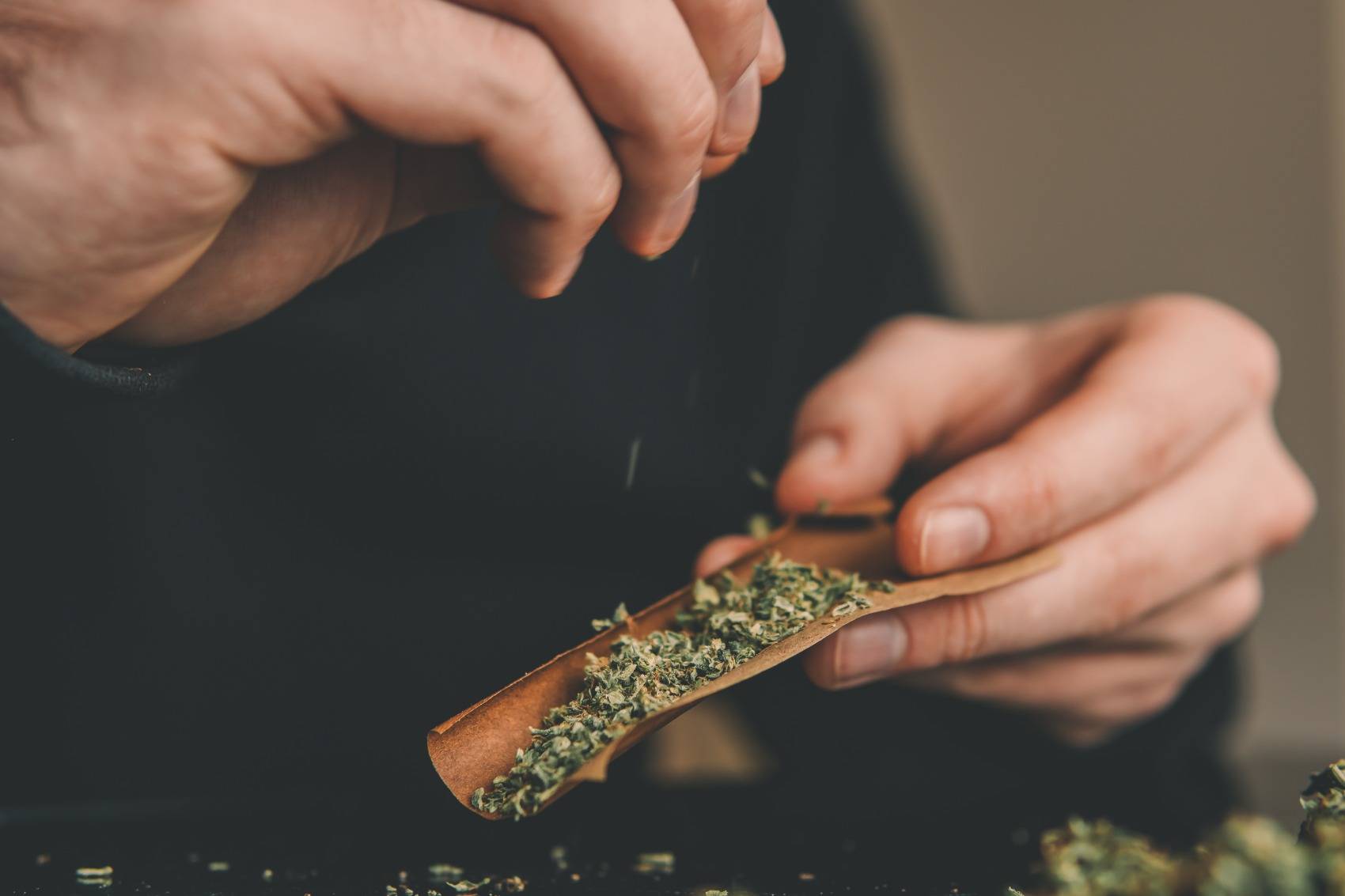 Close up of man enjoying 420 with meaning with a marijuana joint and lighter. SpeedGreens