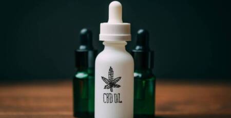 White glass bottle and two green bottles with text CBD Oil. Speed Greens