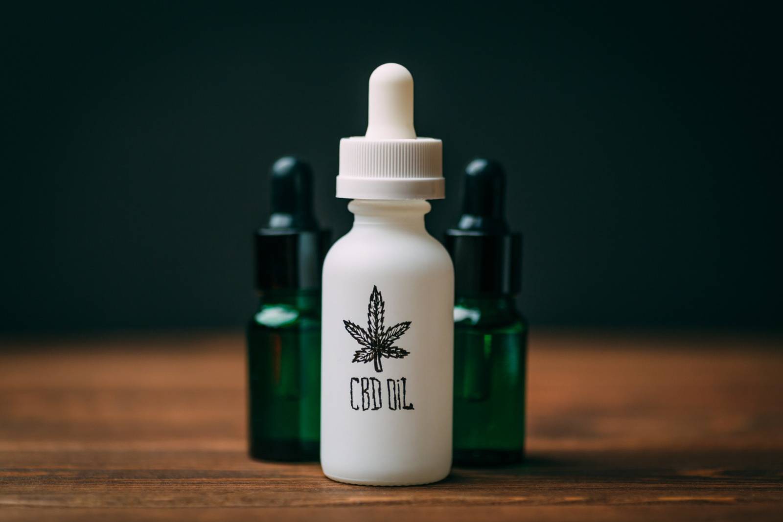White glass bottle and two green bottles with text CBD Oil. Speed Greens
