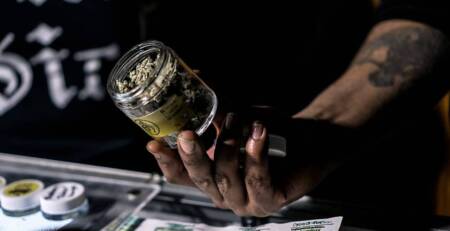 Vendor Showing Off A Jar Of Cannabis Flowers for BC dispensary. Speed Greens